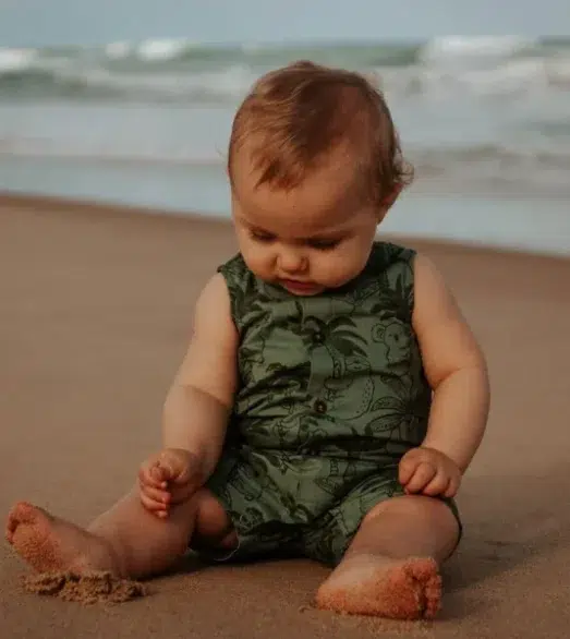 Baby sitzen im Sand am Strand