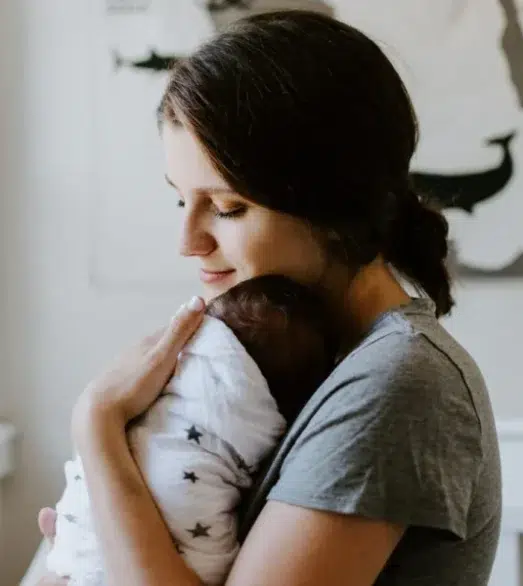 Mutter trägt Baby auf Arm