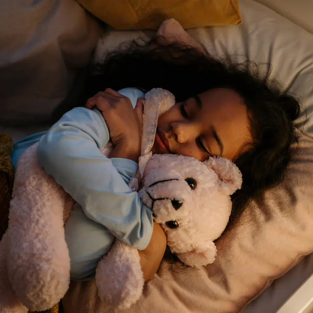 schlafendes Kleinkind mit Teddy in Arm