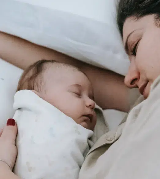 Mutter und Baby in Bett schlafend