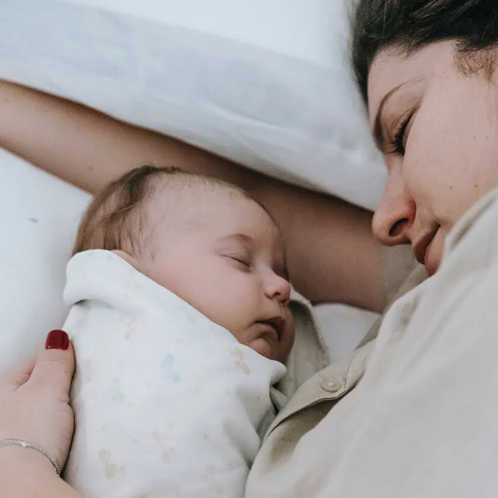 Mutter und Baby in Bett schlafend